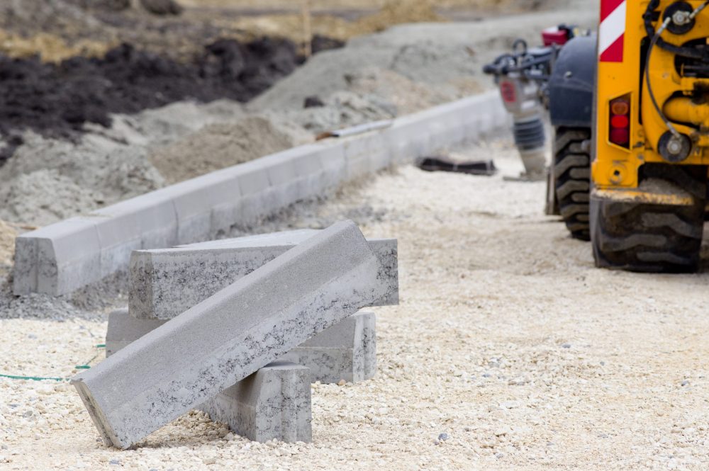 Kerb stones on gravel ground for placing road edge at construction site